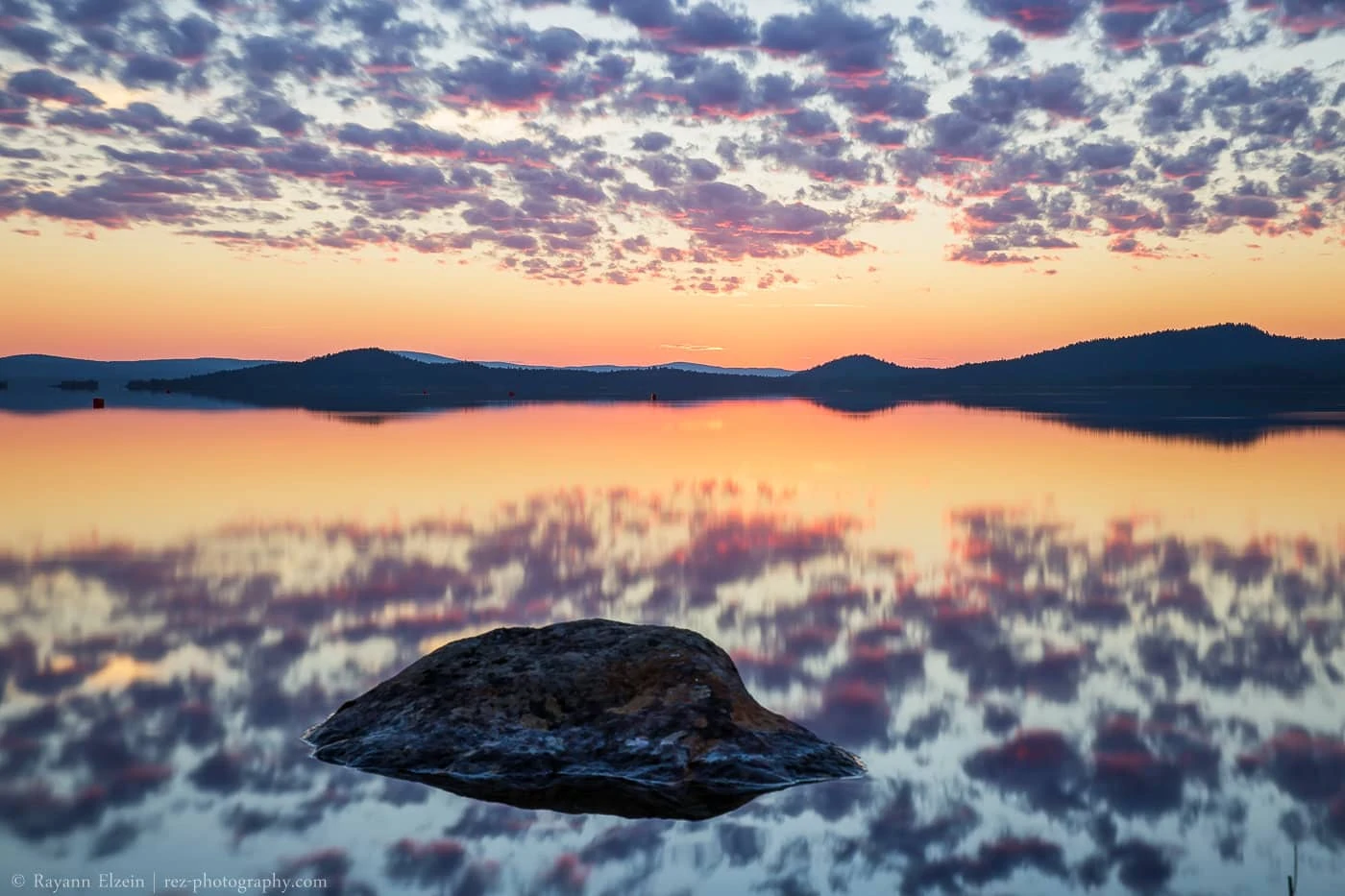 Lac mutusjärvi reflétant parfaitement les nuages roses du premier coucher de soleil après la saison du soleil de minuit