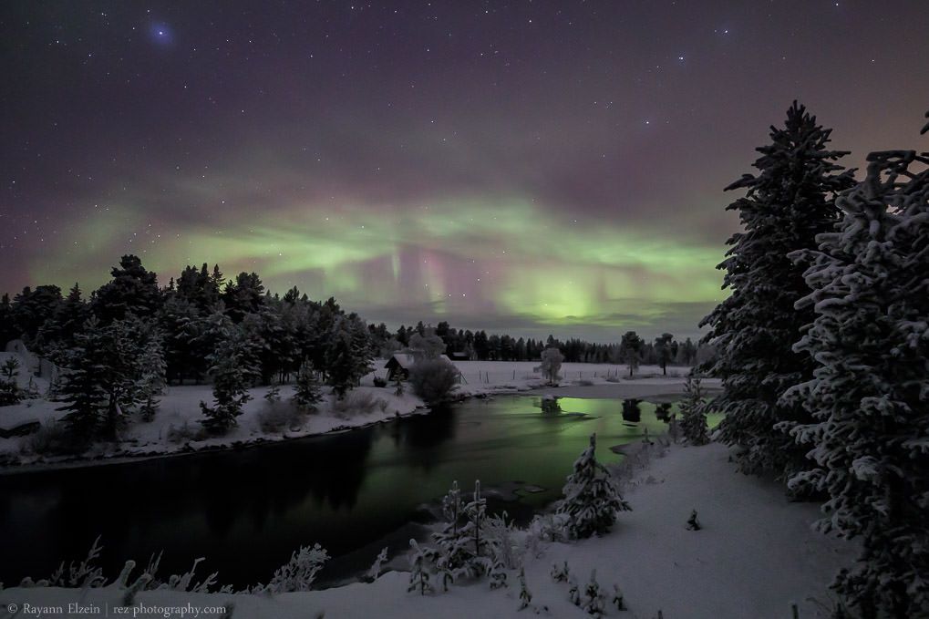 Hunting the Northern Lights in November in Inari, Finnish Lapland, above the river.