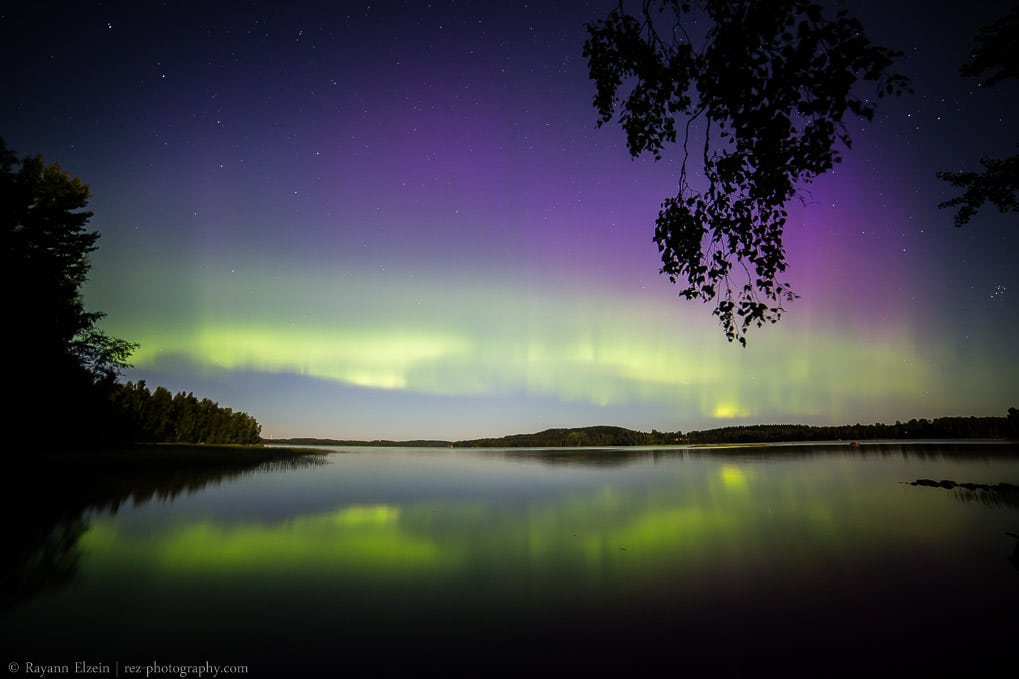 Aurores boréales au bord d'un lac en été dans le sud de la Finlande