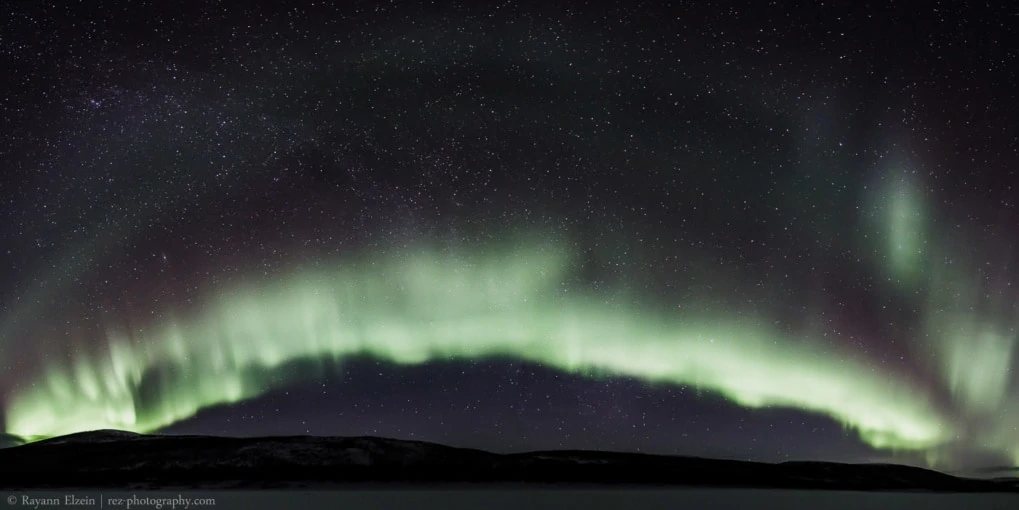 Panorama of aurora borealis above the Teno river in Finnish Lapland