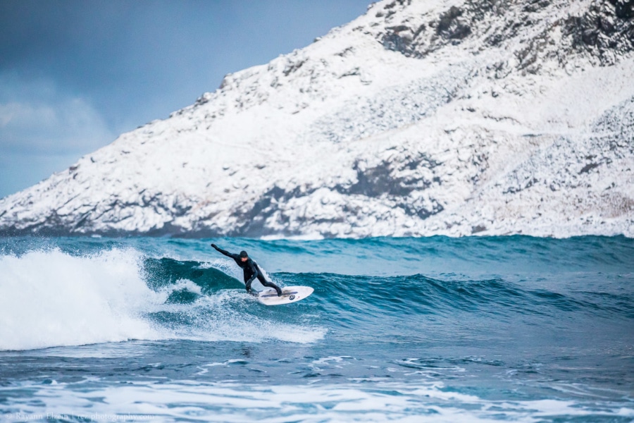 Surfer riding a wave at Unstad Arctic surfing beach in Lofoten